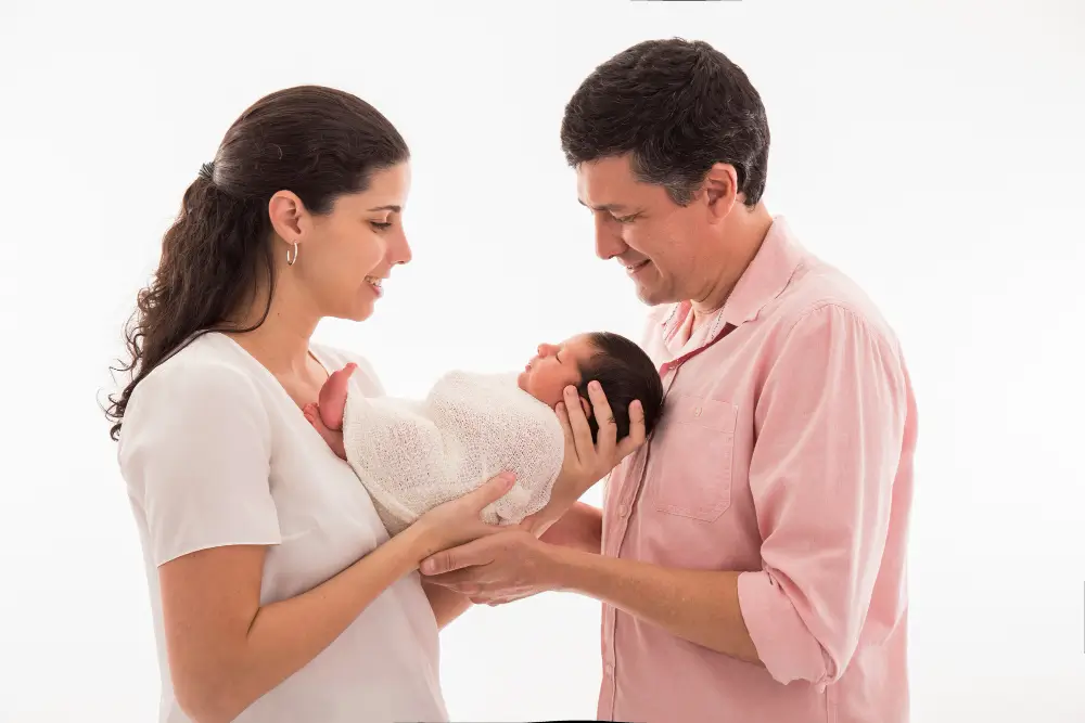 Happy couple holding newborn baby after pregnancy over 30 showing safe motherhood and healthy delivery